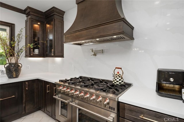 5231 Flora Ct, Rancho Cucamonga, CA 91739 - kitchen with double oven range, custom range hood, light countertops, dark brown cabinetry, and glass insert cabinets