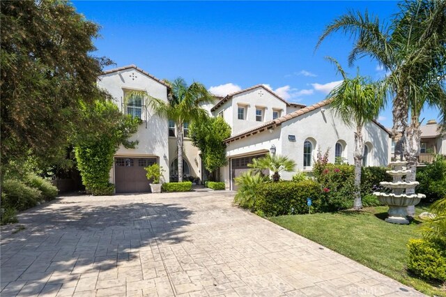 5231 Flora Ct, Rancho Cucamonga, CA 91739 - mediterranean / spanish house featuring stucco siding, decorative driveway, a garage, and a tiled roof