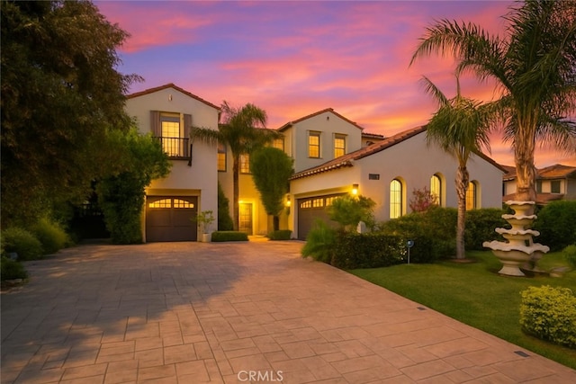 5231 Flora Ct, Rancho Cucamonga, CA 91739 - mediterranean / spanish-style house featuring stucco siding, a tile roof, decorative driveway, and an attached garage