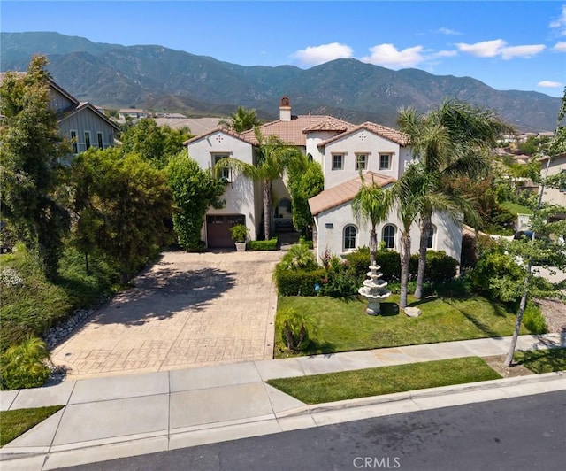 5231 Flora Ct, Rancho Cucamonga, CA 91739 - mediterranean / spanish-style home with a tile roof, a chimney, stucco siding, decorative driveway, and a garage