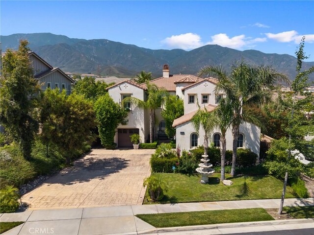 5231 Flora Ct, Rancho Cucamonga, CA 91739 - view of front of home with a chimney, decorative driveway, stucco siding, a tiled roof, and a mountain view