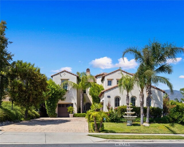 5231 Flora Ct, Rancho Cucamonga, CA 91739 - mediterranean / spanish-style house with decorative driveway, a garage, stucco siding, and a chimney