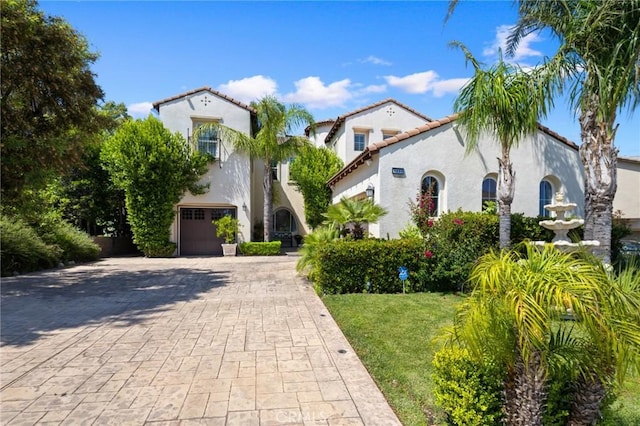 5231 Flora Ct, Rancho Cucamonga, CA 91739 - mediterranean / spanish house featuring decorative driveway, stucco siding, a garage, and a tile roof