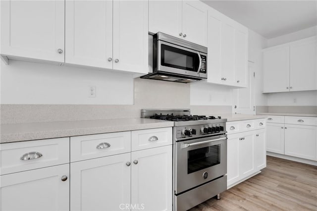 403 Aura Dr, Costa Mesa, CA 92626 - kitchen featuring appliances with stainless steel finishes, white cabinetry, light countertops, and light wood-type flooring