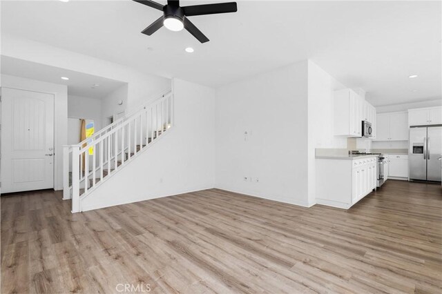 403 Aura Dr, Costa Mesa, CA 92626 - unfurnished living room with stairs, wood finished floors, ceiling fan, and recessed lighting
