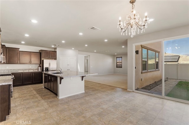 11462 Jacobsen Rd, Beaumont, CA 92223 - kitchen featuring stainless steel appliances, recessed lighting, open floor plan, light stone countertops, and a chandelier