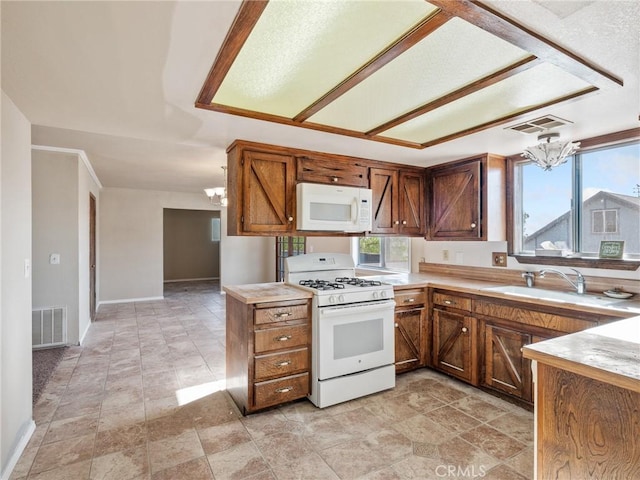 7423 Palomar Ave, Yucca Valley, CA 92284 - kitchen featuring white appliances, a chandelier, light countertops, a peninsula, and stone finish flooring