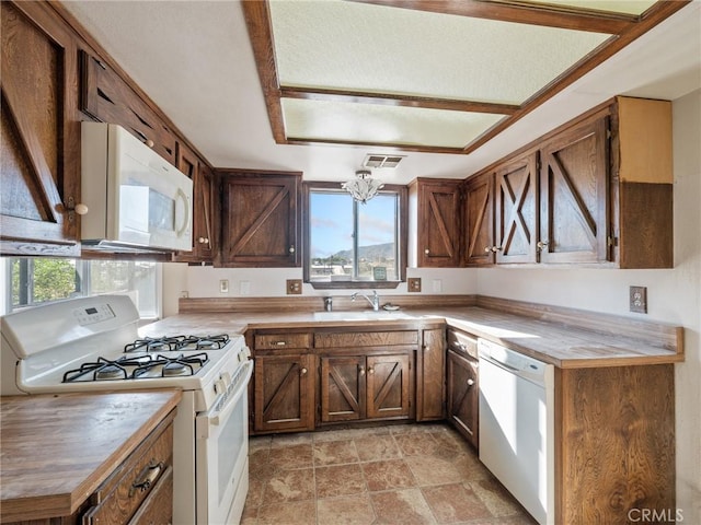 7423 Palomar Ave, Yucca Valley, CA 92284 - kitchen with white appliances, stone finish flooring, a chandelier, and light countertops