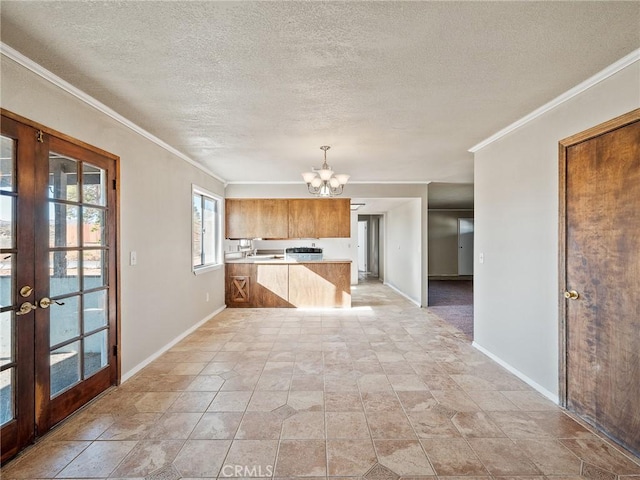 7423 Palomar Ave, Yucca Valley, CA 92284 - kitchen featuring a chandelier, light countertops, a peninsula, french doors, and ornamental molding