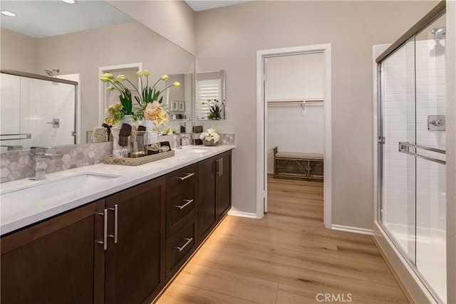 9048 Carson Ave, Hesperia, CA 92344 - bathroom featuring wood finished floors, a shower stall, double vanity, a spacious closet, and recessed lighting