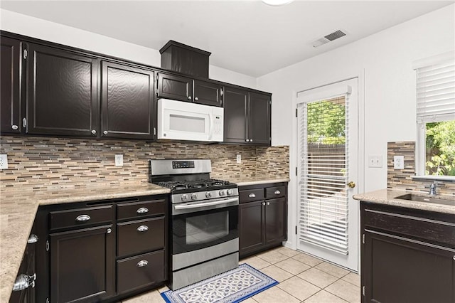 1 Alden Ct, Chico, CA 95973 - kitchen with gas stove, white microwave, light tile patterned flooring, and decorative backsplash