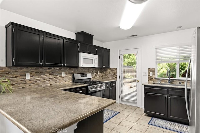 1 Alden Ct, Chico, CA 95973 - kitchen with appliances with stainless steel finishes, dark cabinetry, backsplash, and light tile patterned flooring