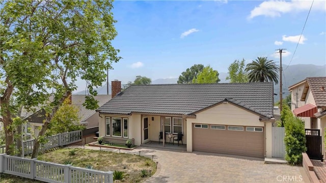 3348 Burritt Way, La Crescenta, CA 91214 - view of front of home featuring a tiled roof, a garage, a chimney, stucco siding, and decorative driveway