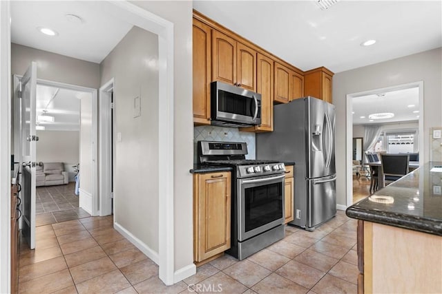 3348 Burritt Way, La Crescenta, CA 91214 - kitchen featuring appliances with stainless steel finishes, light tile patterned flooring, dark stone countertops, decorative backsplash, and recessed lighting