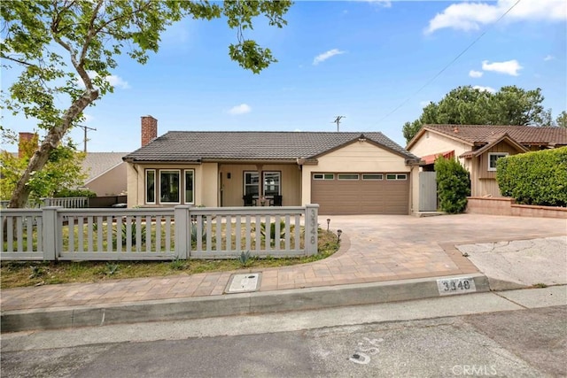 3348 Burritt Way, La Crescenta, CA 91214 - view of front of house featuring a tiled roof, an attached garage, a chimney, a fenced front yard, and driveway