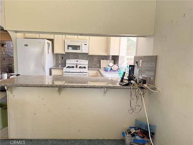 23020 Jensen Ct, Grand Terrace, CA 92313 - kitchen with white appliances, a peninsula, tasteful backsplash, and light stone counters