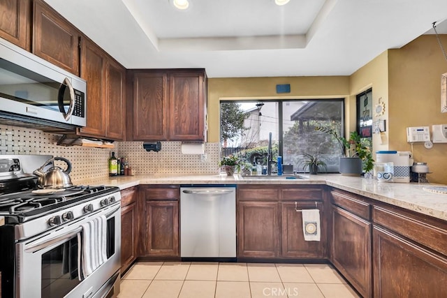 7826 Winnetka Ave, Winnetka, CA 91306 - kitchen featuring appliances with stainless steel finishes, a raised ceiling, and tasteful backsplash