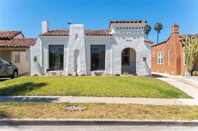 1123 W 81st St, Los Angeles, CA 90044 - mediterranean / spanish-style home featuring a front lawn, a tile roof, and stucco siding