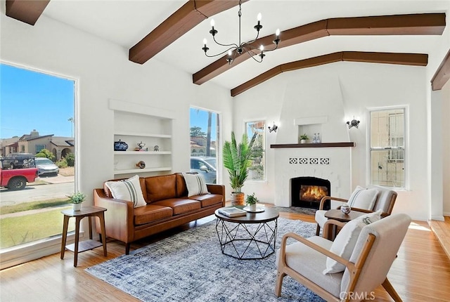 1123 W 81st St, Los Angeles, CA 90044 - living room with built in features, wood finished floors, a large fireplace, and a chandelier