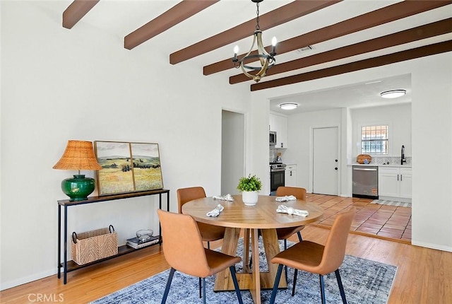 1123 W 81st St, Los Angeles, CA 90044 - dining room featuring a chandelier, beam ceiling, and light wood-style floors