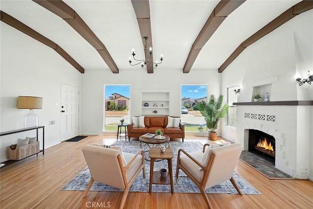 1123 W 81st St, Los Angeles, CA 90044 - living area featuring built in shelves, a chandelier, a fireplace, beamed ceiling, and light wood-type flooring