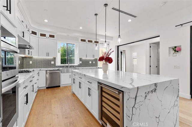 10413 Saint Anna Pl, Fountain Valley, CA 92708 - kitchen with stainless steel appliances, wine cooler, a kitchen island, light wood-type flooring, and recessed lighting