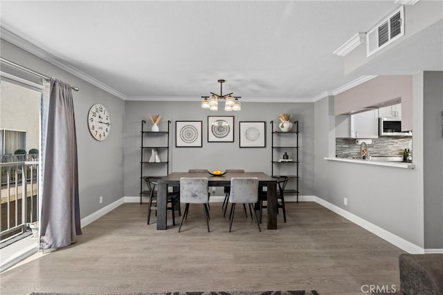 5230 Zelzah Ave Unit 3, Encino, CA 91316 - dining space featuring a chandelier, wood finished floors, and ornamental molding