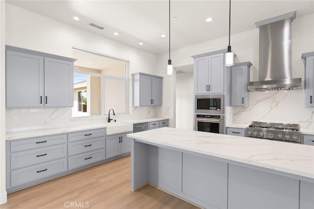 5035 San Juanico Dr, Chico, CA 95973 - kitchen with stainless steel appliances, wall chimney range hood, gray cabinets, and recessed lighting
