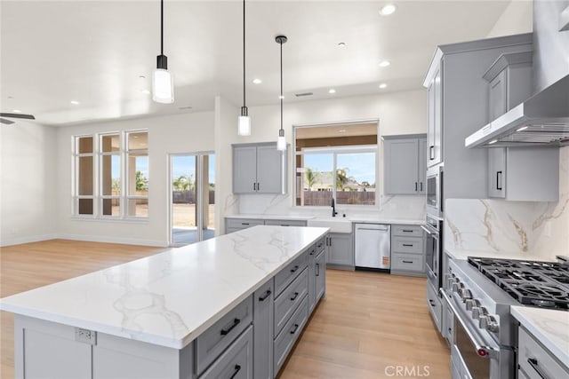 5035 San Juanico Dr, Chico, CA 95973 - kitchen with gray cabinetry, stainless steel appliances, wall chimney exhaust hood, a kitchen island, and tasteful backsplash