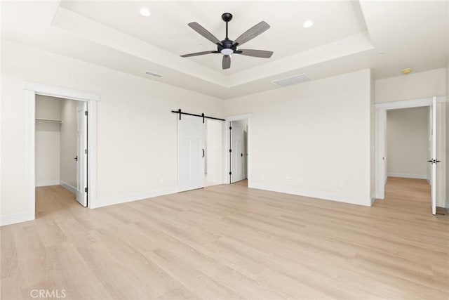 5035 San Juanico Dr, Chico, CA 95973 - unfurnished bedroom with a raised ceiling, light wood finished floors, a walk in closet, recessed lighting, and a ceiling fan