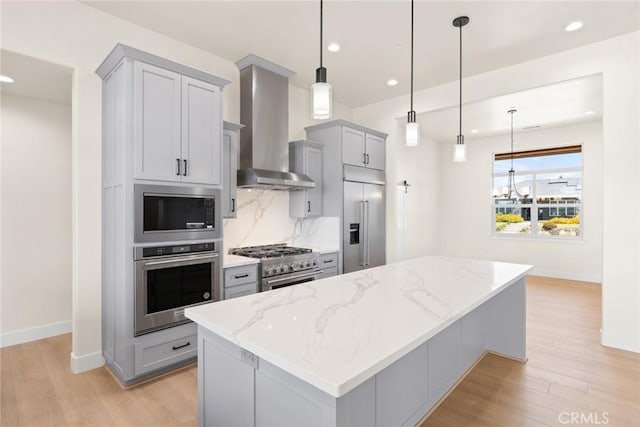 5035 San Juanico Dr, Chico, CA 95973 - kitchen with built in appliances, wall chimney exhaust hood, gray cabinets, light wood-type flooring, and light stone countertops