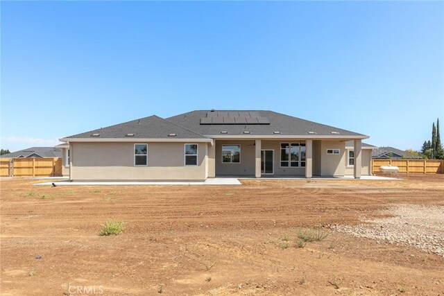 5035 San Juanico Dr, Chico, CA 95973 - rear view of house featuring roof mounted solar panels, stucco siding, a patio, and roof with shingles