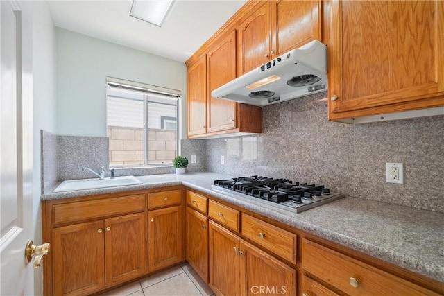 5939 N Vista St, San Gabriel, CA 91775 - kitchen with under cabinet range hood, stainless steel gas stovetop, brown cabinets, and decorative backsplash