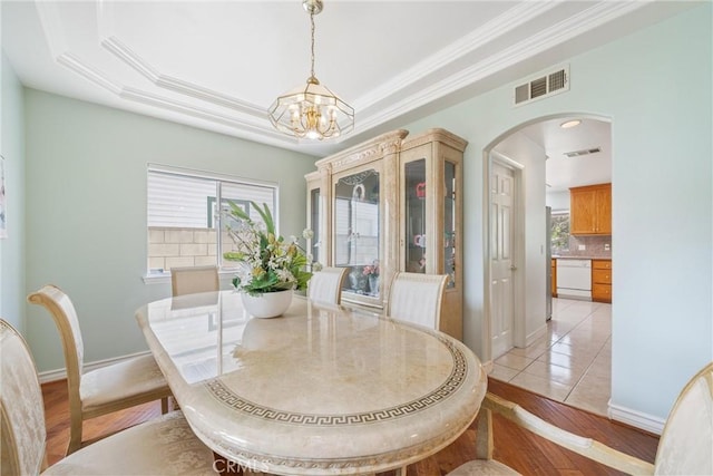 5939 N Vista St, San Gabriel, CA 91775 - dining space with a chandelier, arched walkways, a raised ceiling, ornamental molding, and light wood-type flooring