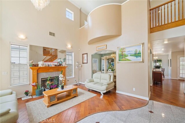 5939 N Vista St, San Gabriel, CA 91775 - living area featuring arched walkways, a tiled fireplace, a towering ceiling, granite tiled floors, and crown molding