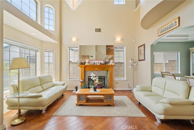 5939 N Vista St, San Gabriel, CA 91775 - living room with a towering ceiling, arched walkways, a fireplace, wood-type flooring, and a chandelier