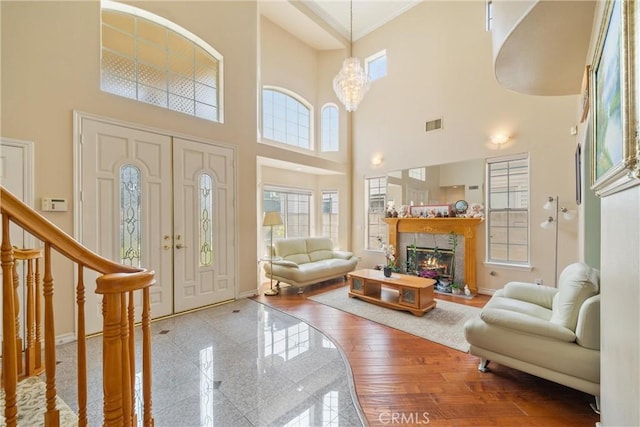5939 N Vista St, San Gabriel, CA 91775 - foyer entrance with a high ceiling, crown molding, a glass covered fireplace, a chandelier, and wood finished floors