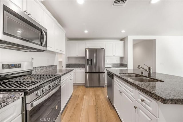 29045 Silver Stirrup Way, Winchester, CA 92596 - kitchen with stainless steel appliances, white cabinetry, light wood-type flooring, recessed lighting, and a kitchen island with sink