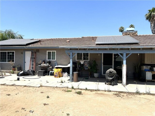 1061 N Perris Blvd, Perris, CA 92571 - back of house featuring solar panels, a patio area, stucco siding, and a chimney