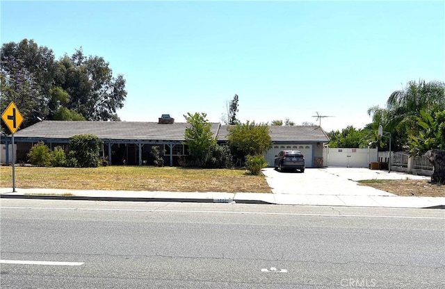 1061 N Perris Blvd, Perris, CA 92571 - ranch-style house featuring concrete driveway, a garage, and a chimney