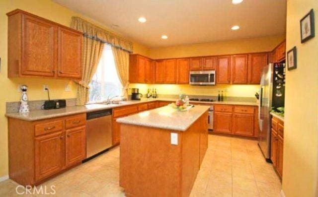 45211 Tioga St, Temecula, CA 92592 - kitchen with stainless steel appliances, a kitchen island, light countertops, recessed lighting, and light tile patterned floors