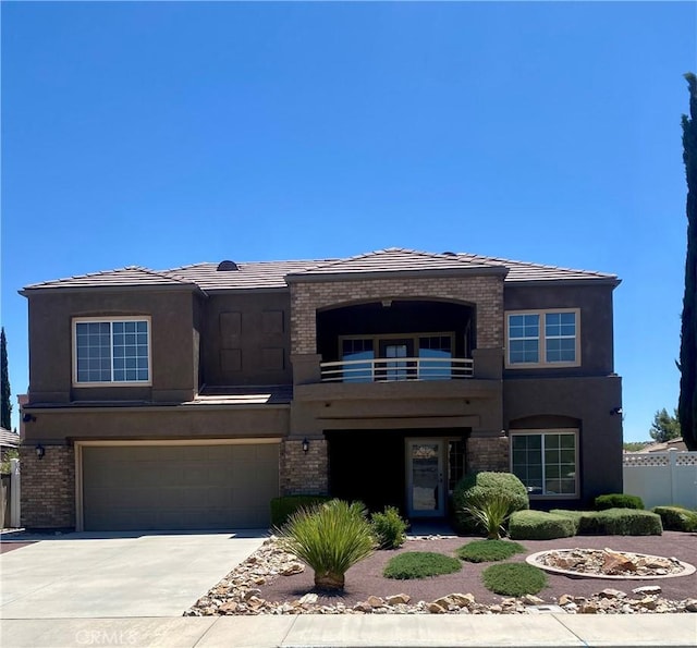 38736 Elder Creek Ct, Palmdale, CA 93551 - view of front of house with a balcony, an attached garage, brick siding, driveway, and stucco siding