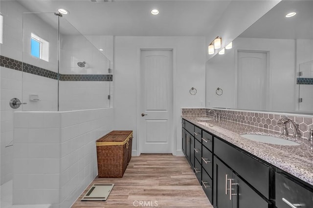 253 Peters Ln S, Madera, CA 93636 - full bath with double vanity, wood finished floors, tiled shower, recessed lighting, and decorative backsplash