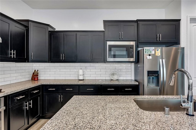 253 Peters Ln S, Madera, CA 93636 - kitchen featuring stainless steel appliances, dark cabinets, and light stone countertops