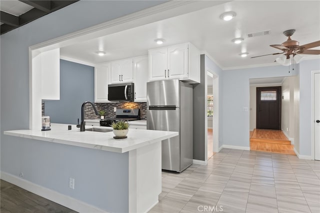 11142 Bertha Pl, Cerritos, CA 90703 - kitchen with stainless steel appliances, light stone counters, backsplash, a peninsula, and white cabinetry