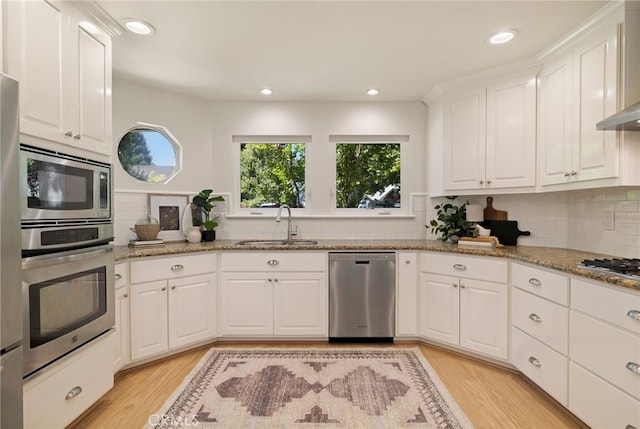 812 Collindale Ct, Chico, CA 95926 - kitchen with appliances with stainless steel finishes, light wood finished floors, tasteful backsplash, white cabinetry, and recessed lighting