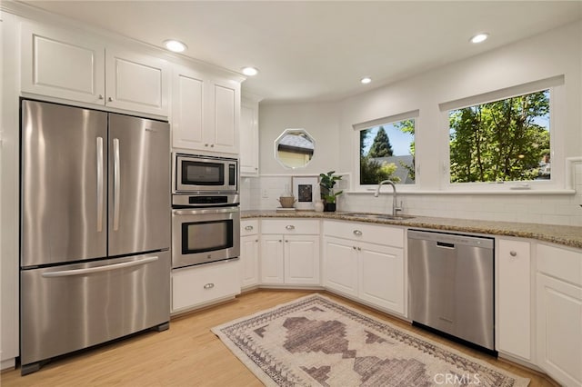 812 Collindale Ct, Chico, CA 95926 - kitchen with stainless steel appliances, light wood finished floors, decorative backsplash, light stone countertops, and white cabinets