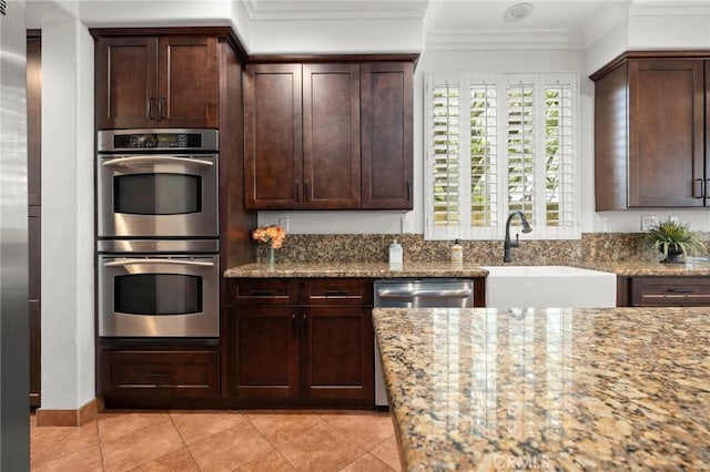 1737 Partridge Ave, Upland, CA 91784 - kitchen featuring stainless steel appliances, light stone countertops, light tile patterned floors, crown molding, and dark brown cabinetry