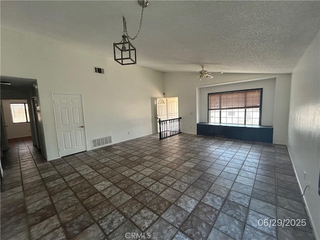 467 Stanford Dr, Barstow, CA 92311 - unfurnished living room featuring a ceiling fan, a textured ceiling, and plenty of natural light