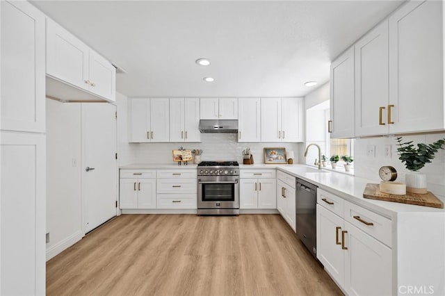 5731 Applecross Dr, Riverside, CA 92507 - kitchen with appliances with stainless steel finishes, under cabinet range hood, light wood finished floors, decorative backsplash, and recessed lighting
